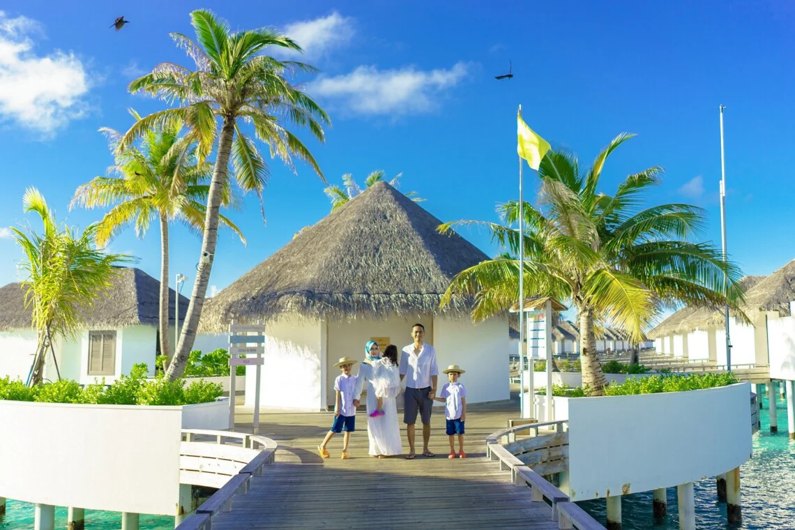 Family portrait in front of villas in Maldive