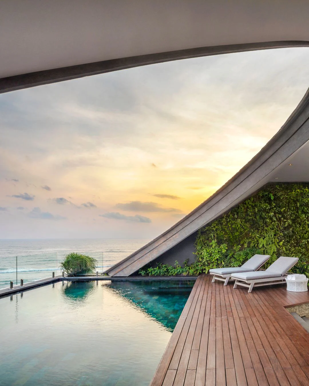 Curved-roof beachfront villa with infinity pool, sun loungers and ocean view at COMO Uma Canggu